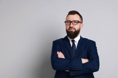 Gri arka planda takım elbiseli yakışıklı sakallı adam. Metin için boşluk