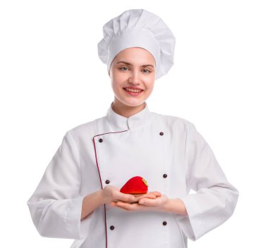 Üniformalı mutlu pastacı beyaz arka planda lezzetli çilek şekilli tatlı tutuyor.