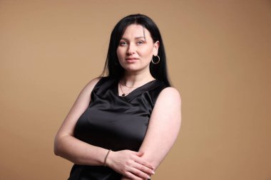 Bej arka planda çekici ve büyük beden modelinin portresi. Fazla kilolu