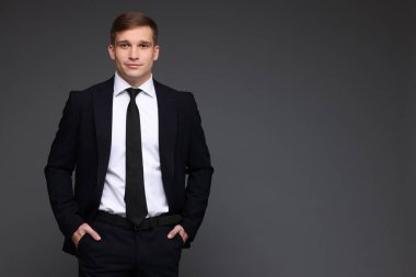 Gri arka planda klasik takım elbiseli bir adam. Metin için boşluk