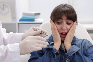 Klinikte dişçiyle randevusu olan korkmuş bir kadın.