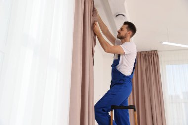 Üniformalı işçiler pencere perdeleri kapalı, düşük açılı.