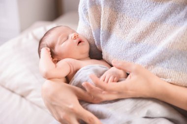 Yatma vakti. Anne evde uyuyan bebeğiyle, yakın plan.