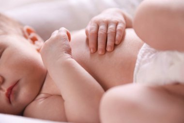 Küçük bebek yatakta uyuyor, yakın plan.