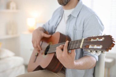 Evde gitar çalan adam, eline odaklan.