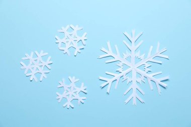 Açık mavi zemin üzerinde güzel kar taneleri, düz uzanmış.