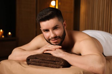 Güzellik salonunda masaj masasında yatan yakışıklı adam.