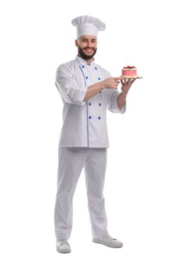 Üniformalı mutlu pastacı elinde beyaz arka planda böğürtlenli kek tutuyor.