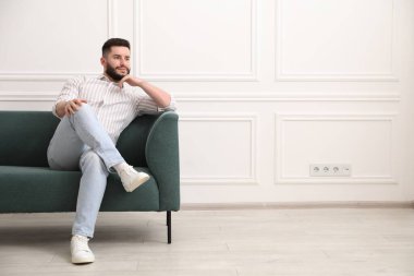 Evdeki kanepede dinlenen yakışıklı adam. Metin için boşluk