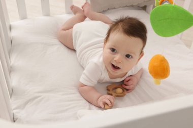 Evinde bebek karyolası olan küçük şirin bir bebek.