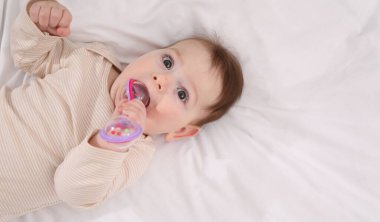 Evdeki yatağında çıngıraklı oyuncağı olan sevimli bir bebek. Metin için boşluk