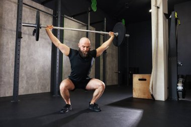 Spor salonunda spor yaparken halterli sporcu