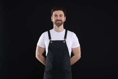 Siyah arka planda gülümseyen baristanın portresi