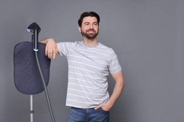 Gri arka planda vapuru olan bir adam.