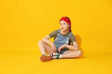 Sarı arka planda dans eden şık elbiseli kız.