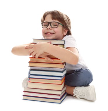 Beyaz arka plan hakkında çok farklı kitapları olan bir çocuk.