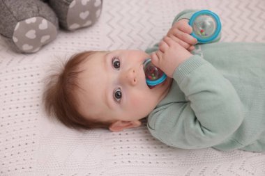 Evdeki beşiğinde çıngıraklı oyuncağı olan şirin bir bebek.