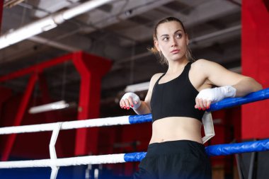 Boks ringinde koruyucu eldivenleri olan bir kadın, düşük açılı. Metin için boşluk