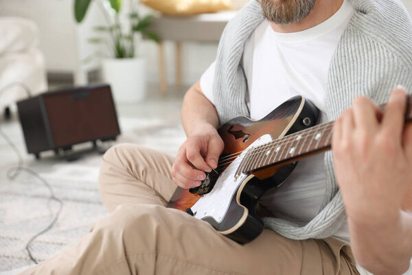 Man playing guitar at home, selective focus