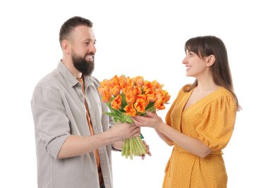 Adam beyaz arka planda sevgili karısına güzel laleler sunuyor.
