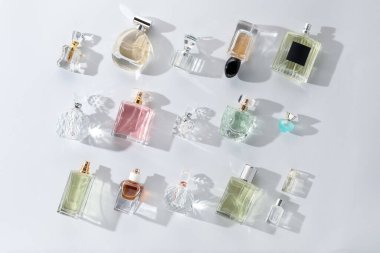 Hafif arka planda çeşitli parfüm şişeleri, düz yatıyordu.