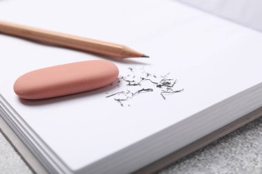 Silgi, kalem, defter ve kırıntılar gri masada, yakın plan