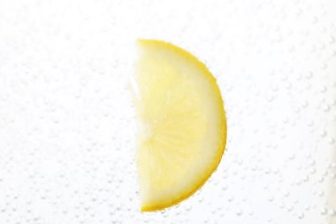 Soda water with lemon slice as background, closeup