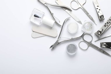 Beyaz arka planda farklı manikür aletleri var. Metin için boşluk