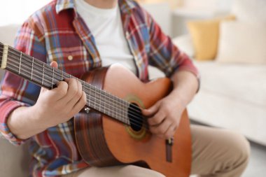 Evde gitar çalan adam, eline odaklan.