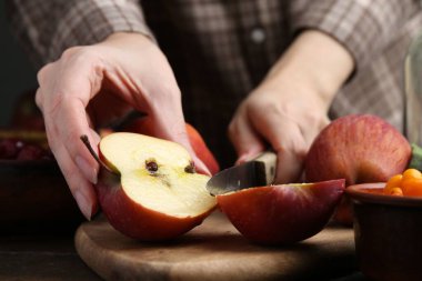 Ahşap masada elma kesen kadın, yakın plan.