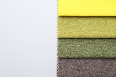 Beyaz arka planda farklı kumaş örnekleri, üst manzara. Metin için boşluk