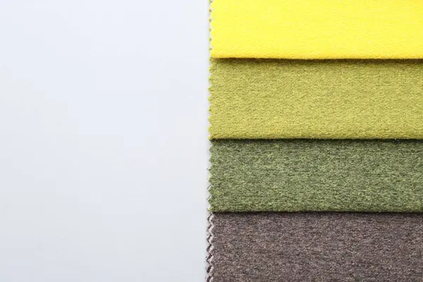 Beyaz arka planda farklı kumaş örnekleri, üst manzara. Metin için boşluk