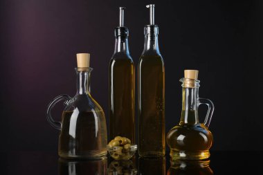 Aynanın yüzeyinde salata sosları ve zeytinler koyu arka planda.