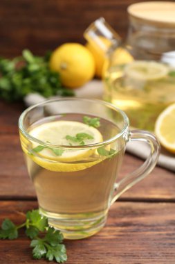 Tahta masada limon dilimleri olan sağlıklı maydanoz çayı. Detoks içeceği