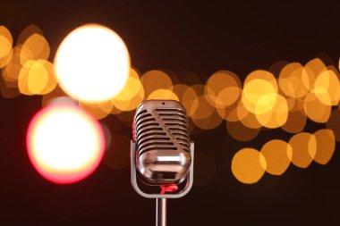 Karanlık arka planda bulanık ışıkları olan klasik mikrofon, mesaj için yer. Müzik ekipmanları