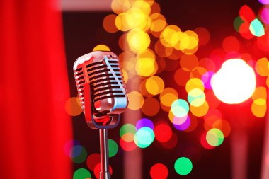 Kırmızı perdeye karşı bir klasik mikrofon, mesaj için yer. Bokeh etkisi