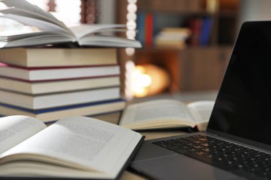 İçerideki masada birçok kitap ve dizüstü bilgisayar var.