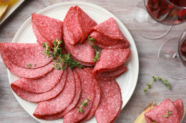 Dilimler dolusu lezzetli sosis ve kekik hafif ahşap masada servis edilir.