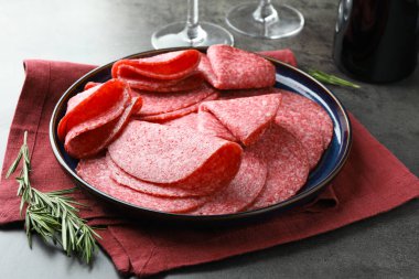 Gri masada servis edilen lezzetli sosisler, yakın plan.