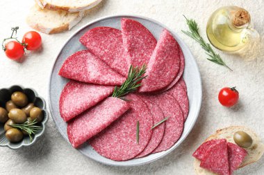 Beyaz desenli masada servis edilen biberiyeli leziz sosis dilimleri.