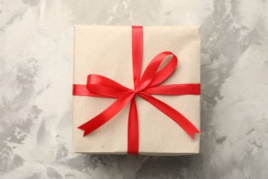 Kraft kağıdına sarılı bir hediye, gri desenli arka plan, üst görünüm