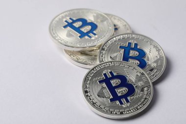 Kripto para birimi. Işık arkaplan üzerinde birçok gümüş bitcoin, yakın plan