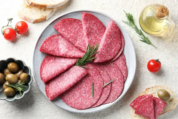 Beyaz desenli masada servis edilen biberiyeli leziz sosis dilimleri.