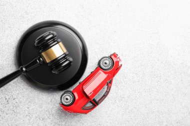 Motorlu taşıt kazası yasası. Gri arka planda Gavel ve araba modeli. Metin için boşluk