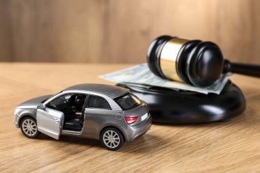 Motorlu taşıt kazası yasası. Gavel, para ve araba modeli ahşap arka planda, yakın plan.