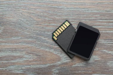 Gri ahşap masada iki SD hafıza kartı var. Metin için boşluk