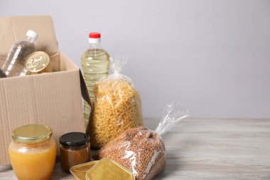 Farklı gıda ürünleri ve ahşap masa üzerinde kutu hafif arkaplan, metin için alan