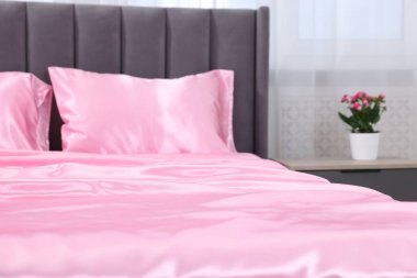 Lüks ipek çarşaflar evdeki yatakta, yakın plan.