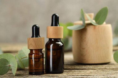 Kaliteli yağ ve okaliptüs yaprakları ahşap masada, yakın plan.