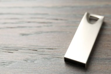 Tahta arka planda bir flaş bellek, yakın plan. Metin için boşluk